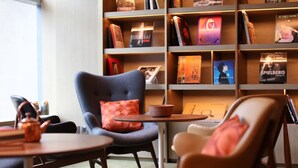 Un rincón acogedor para leer con una estantería, dos sillones, una mesita y un hervidor de té.