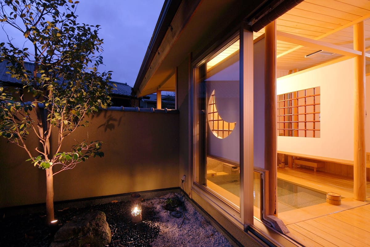 Ein traditionelles japanisches Gebäude mit Holzfassade und Glastür zu einem Raum mit Tatami-Matten.
