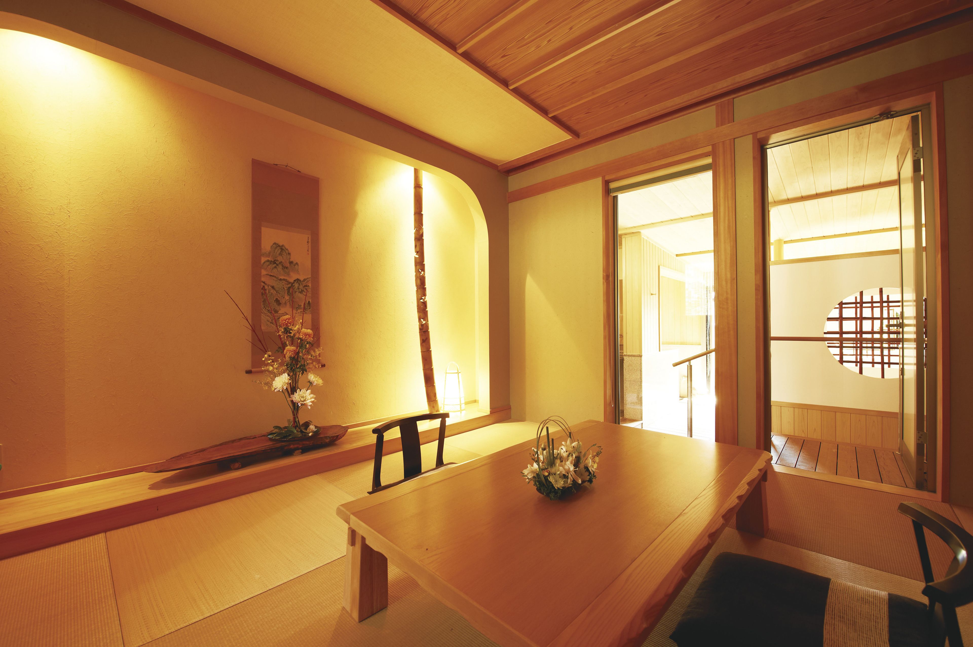 A traditional Japanese room with tatami flooring, a low wooden table, and a shoji screen door.