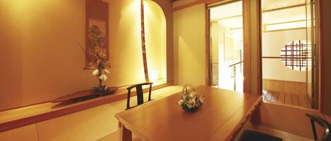 A traditional Japanese room with tatami flooring, a low wooden table, and a shoji screen door.