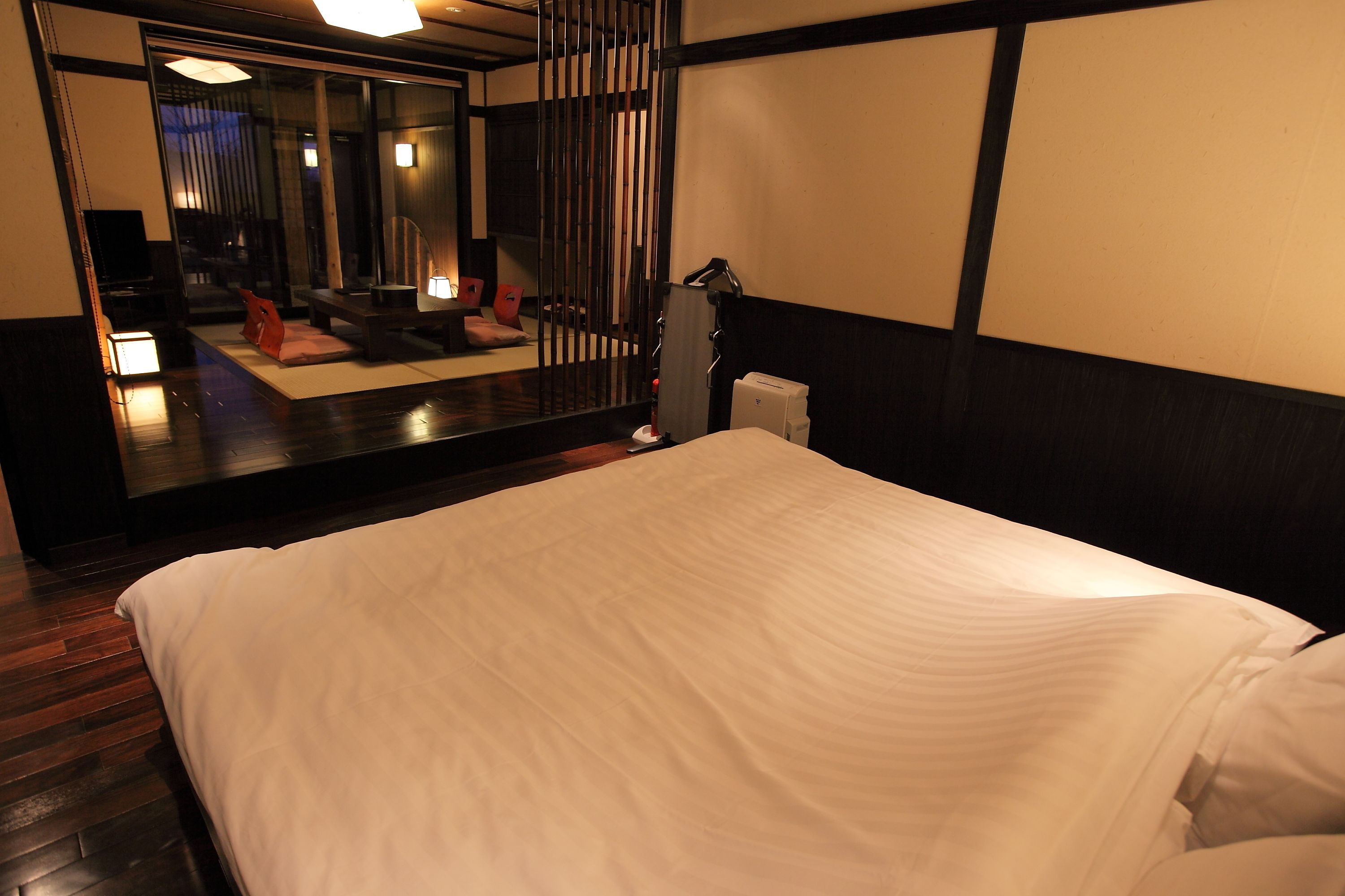 Une chambre d’hôtel avec un grand lit, un miroir, un bureau et une chaise.
