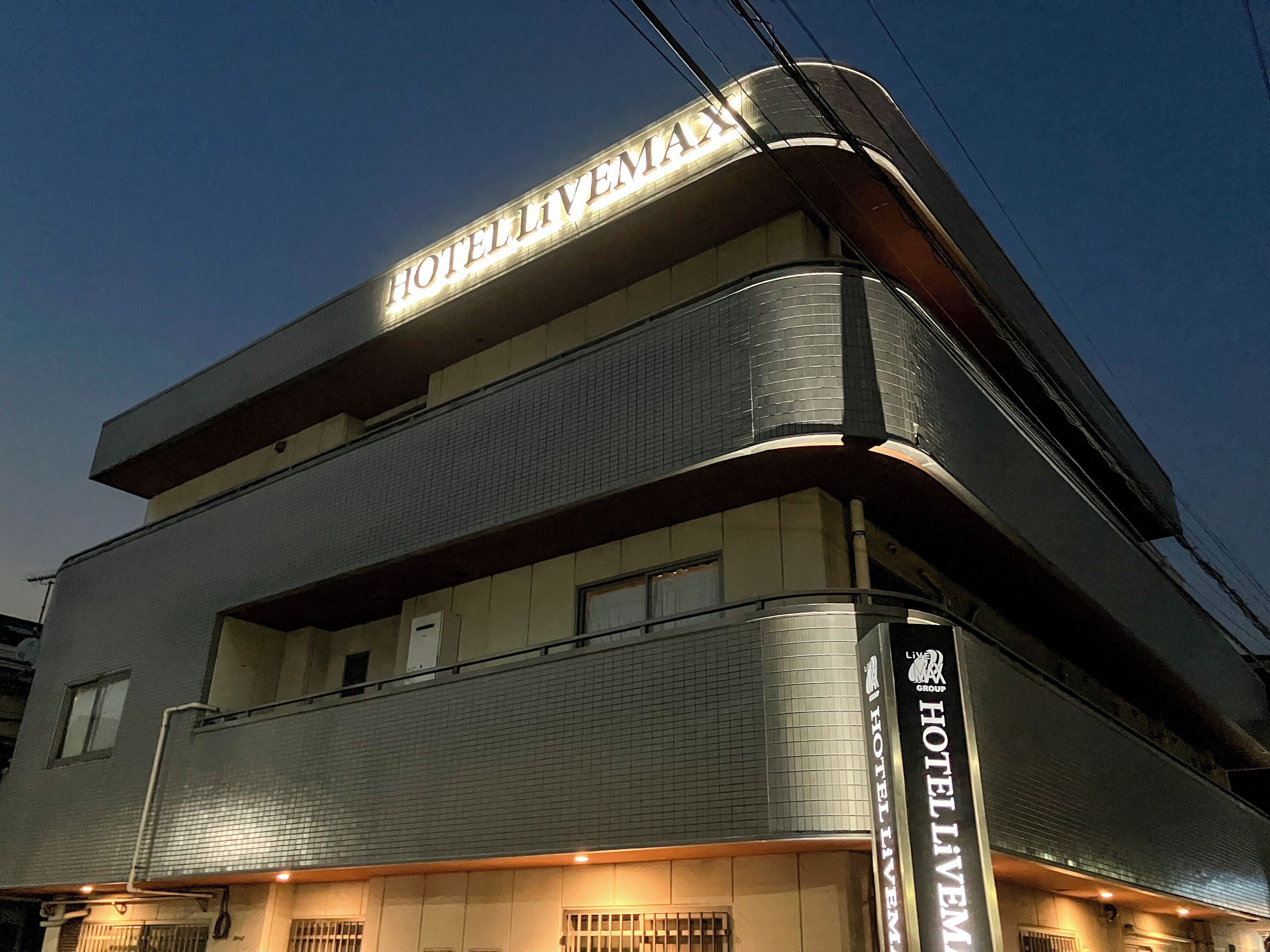 A hotel building with a prominent 'HOTEL LIVING' sign on the facade.