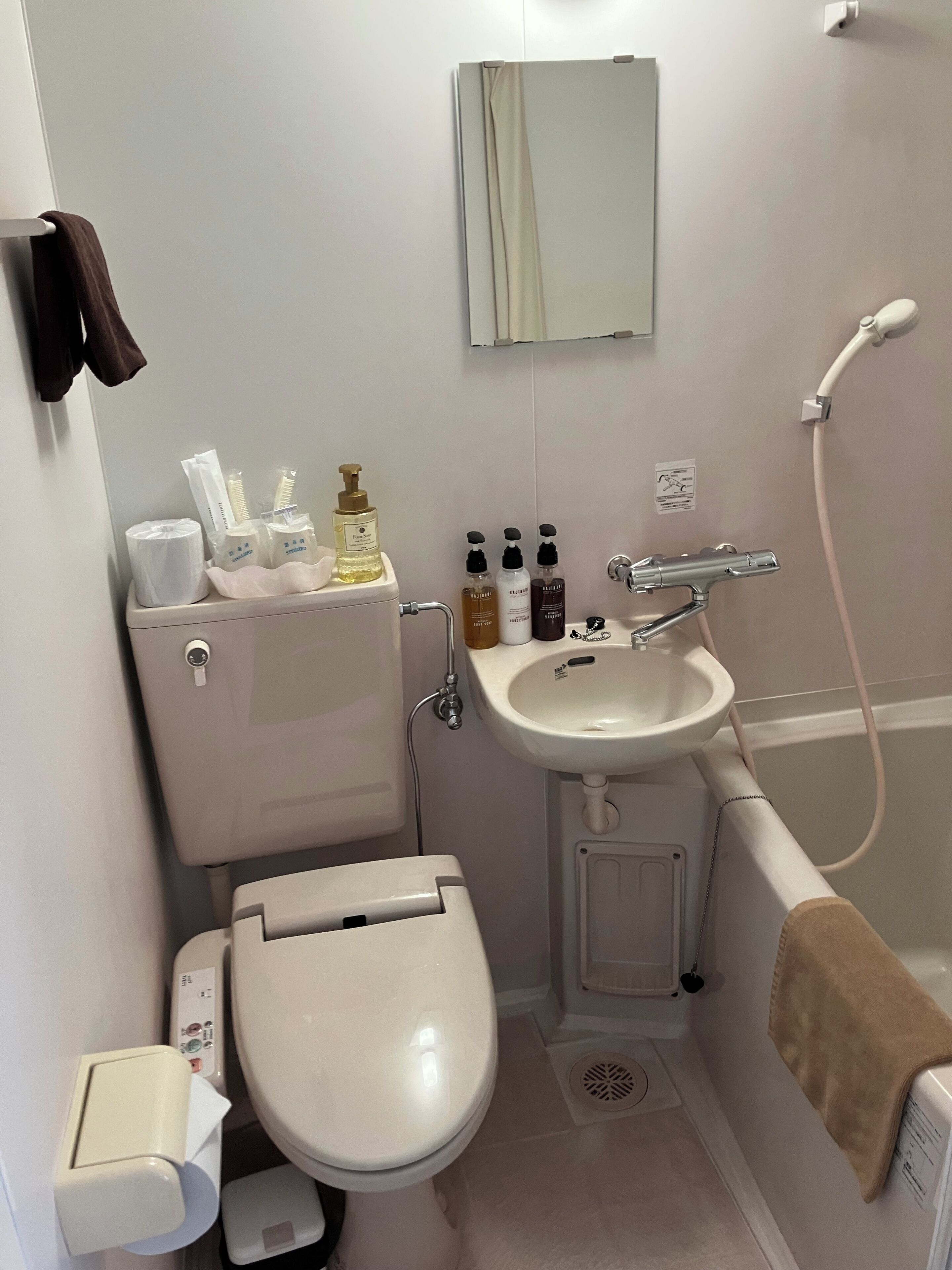 A bathroom with a toilet, sink, and shower.