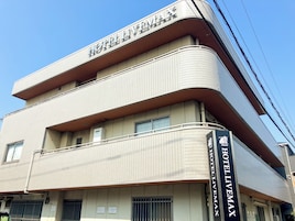Un edificio de hotel de varios pisos con fachada de azulejos y un letrero destacado que dice 'HOTEL LITEMAX'.