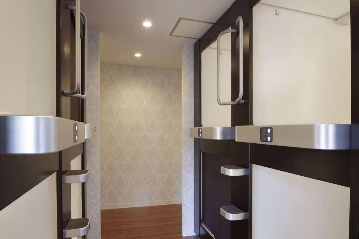 Um corredor com design moderno, com armários metálicos e piso de madeira.