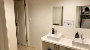 A bathroom with two sinks, a mirror, a toilet, and a shower. - HOTEL LiVEMAX BUDGET Kawasaki Daishi (Kawasaki)