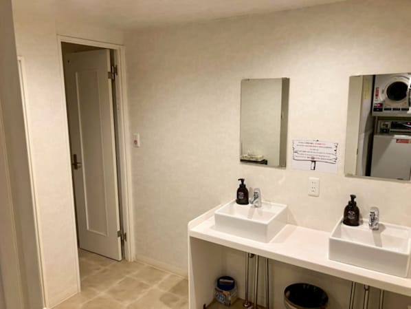 A bathroom with two sinks, a mirror, a toilet, and a shower. - HOTEL LiVEMAX BUDGET Kawasaki Daishi (Kawasaki)