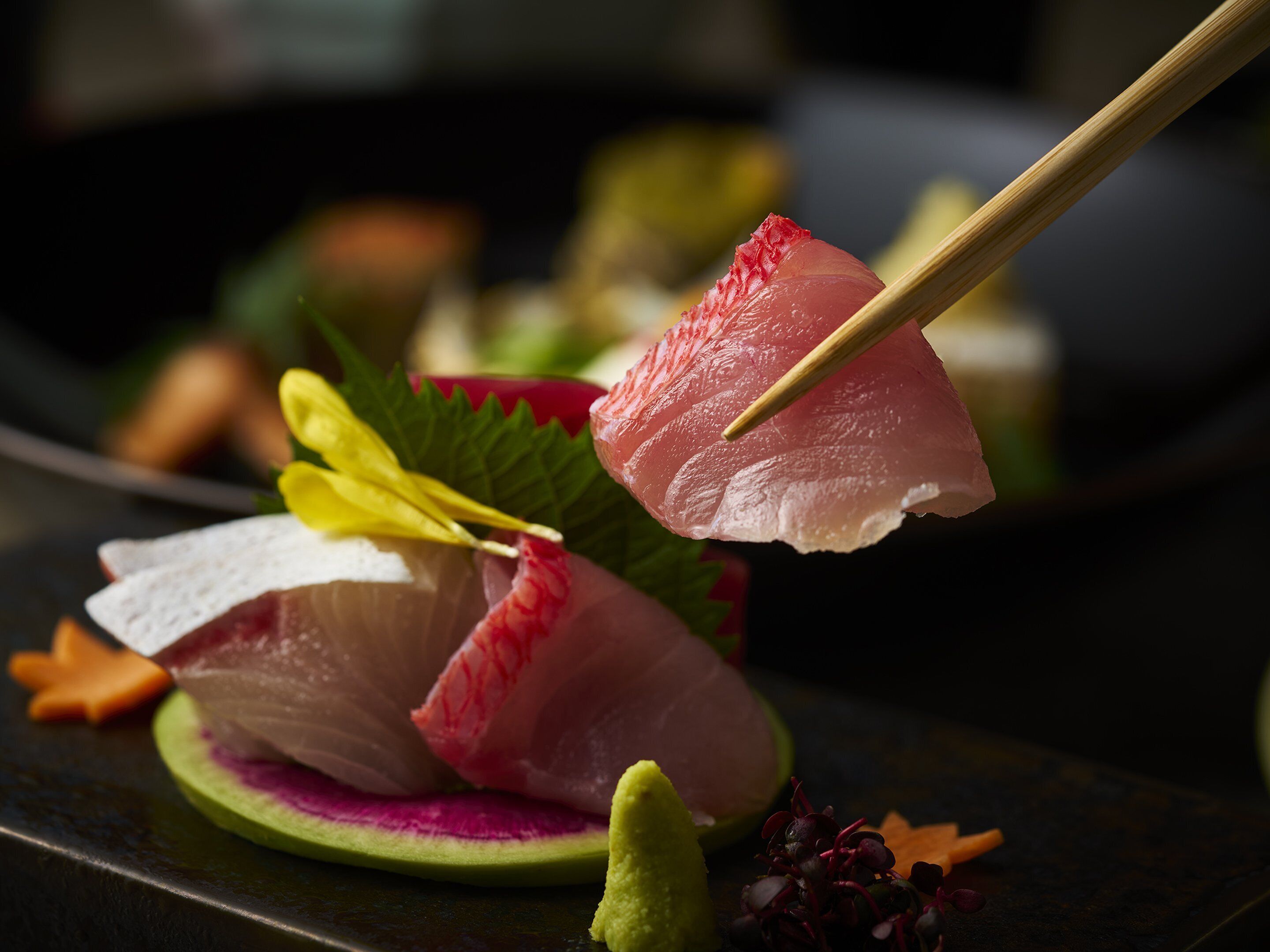 A sushi platter with various types of fish and garnishes.