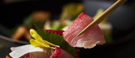 A sushi platter with various types of fish and garnishes.