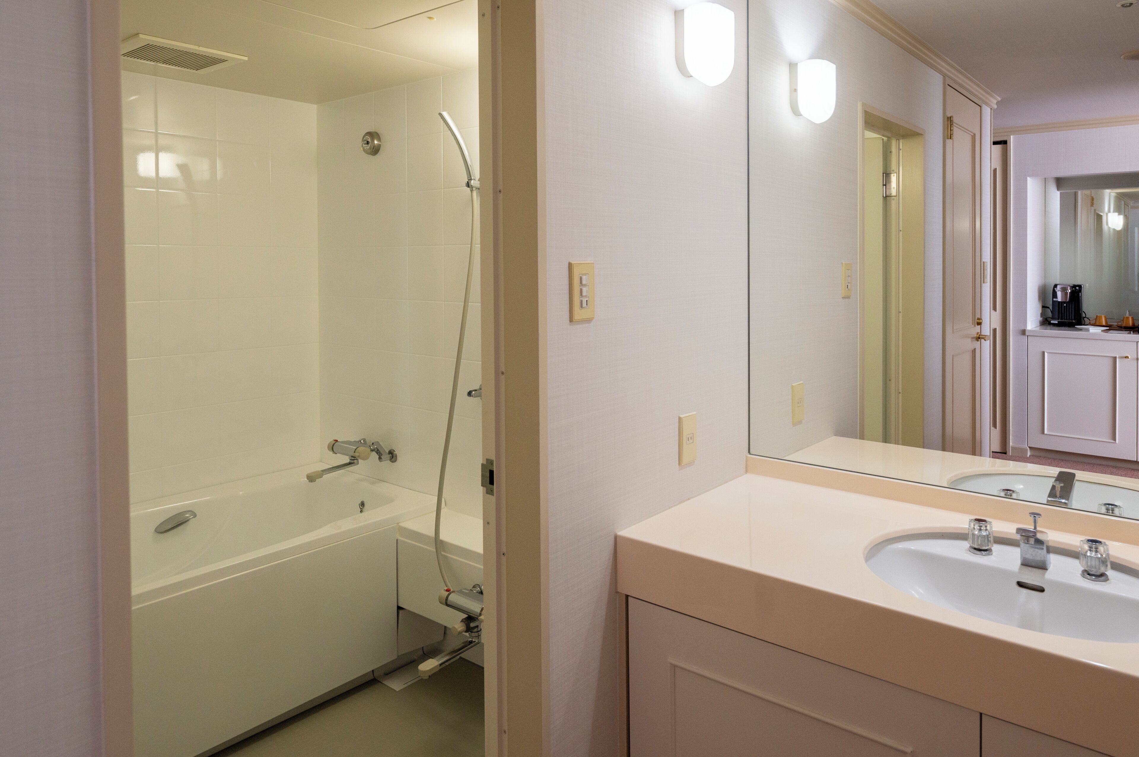 Ein Badezimmer mit einer weißen Badewanne, einer Dusche und einem Waschbecken mit Spiegel.
