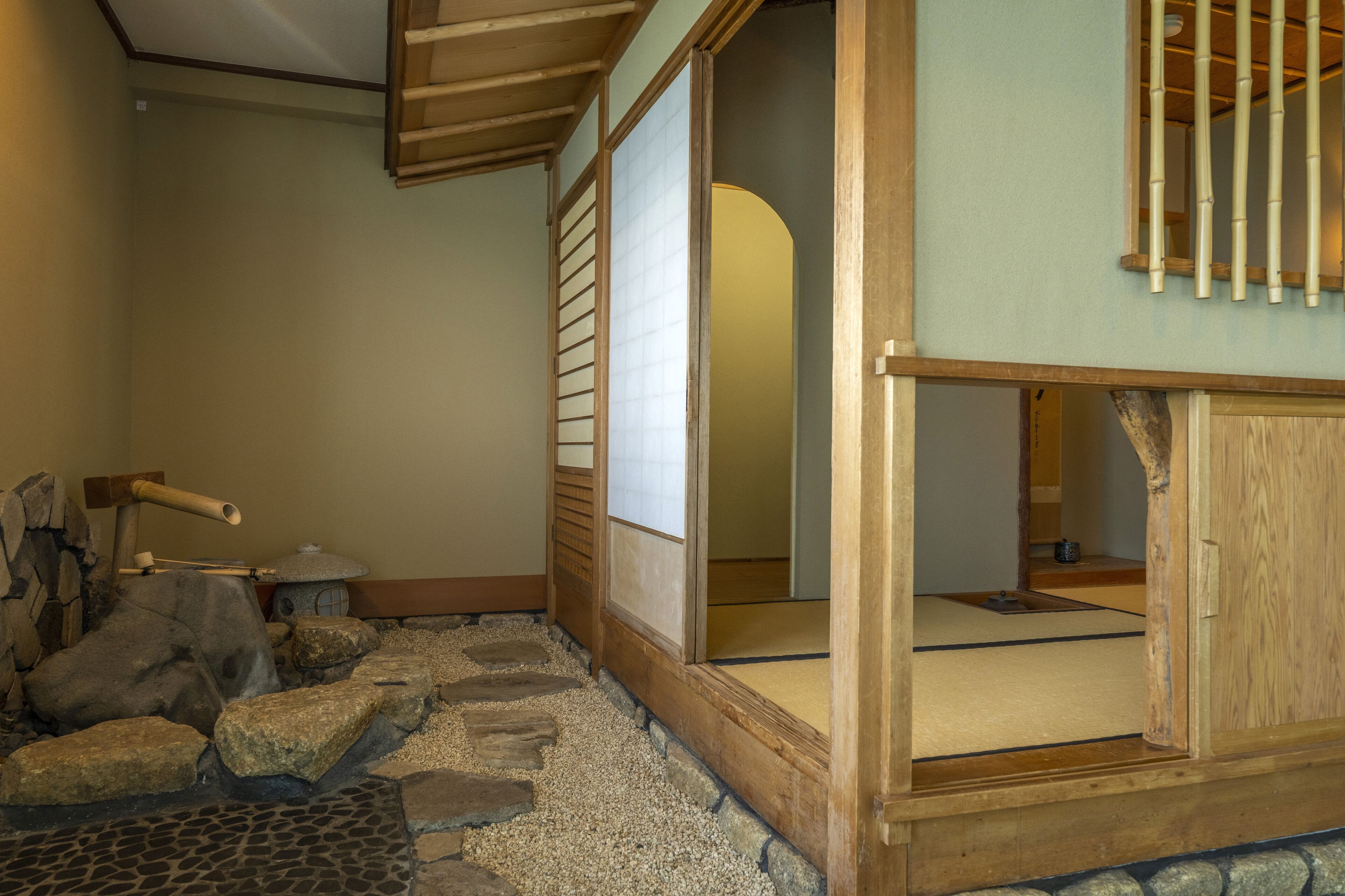 A traditional Japanese room with tatami flooring, a shoji screen door, and a wooden interior.