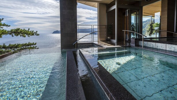 An infinity pool with clear water, a view of the sea, and a modern architectural design. - Hotel New Akao (Atami)