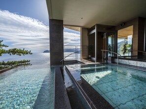 An infinity pool with clear water, a view of the sea, and a modern architectural design. - Hotel New Akao (Atami)