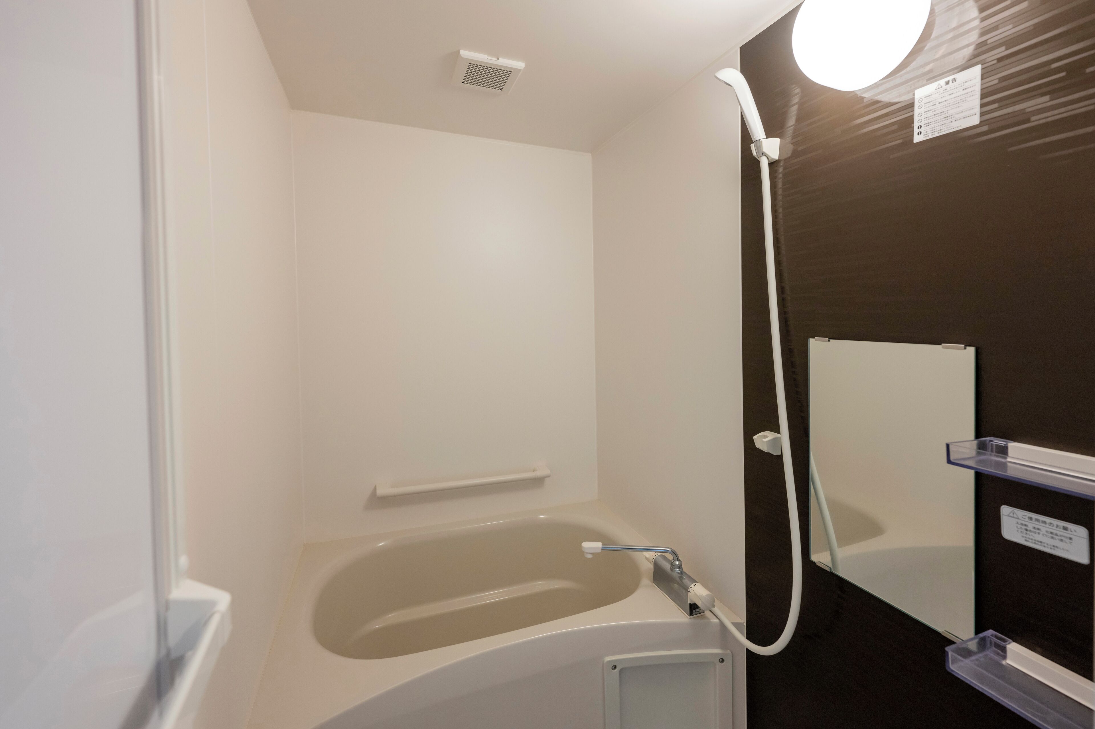 A modern bathroom with a bathtub, a shower, and a mirror.