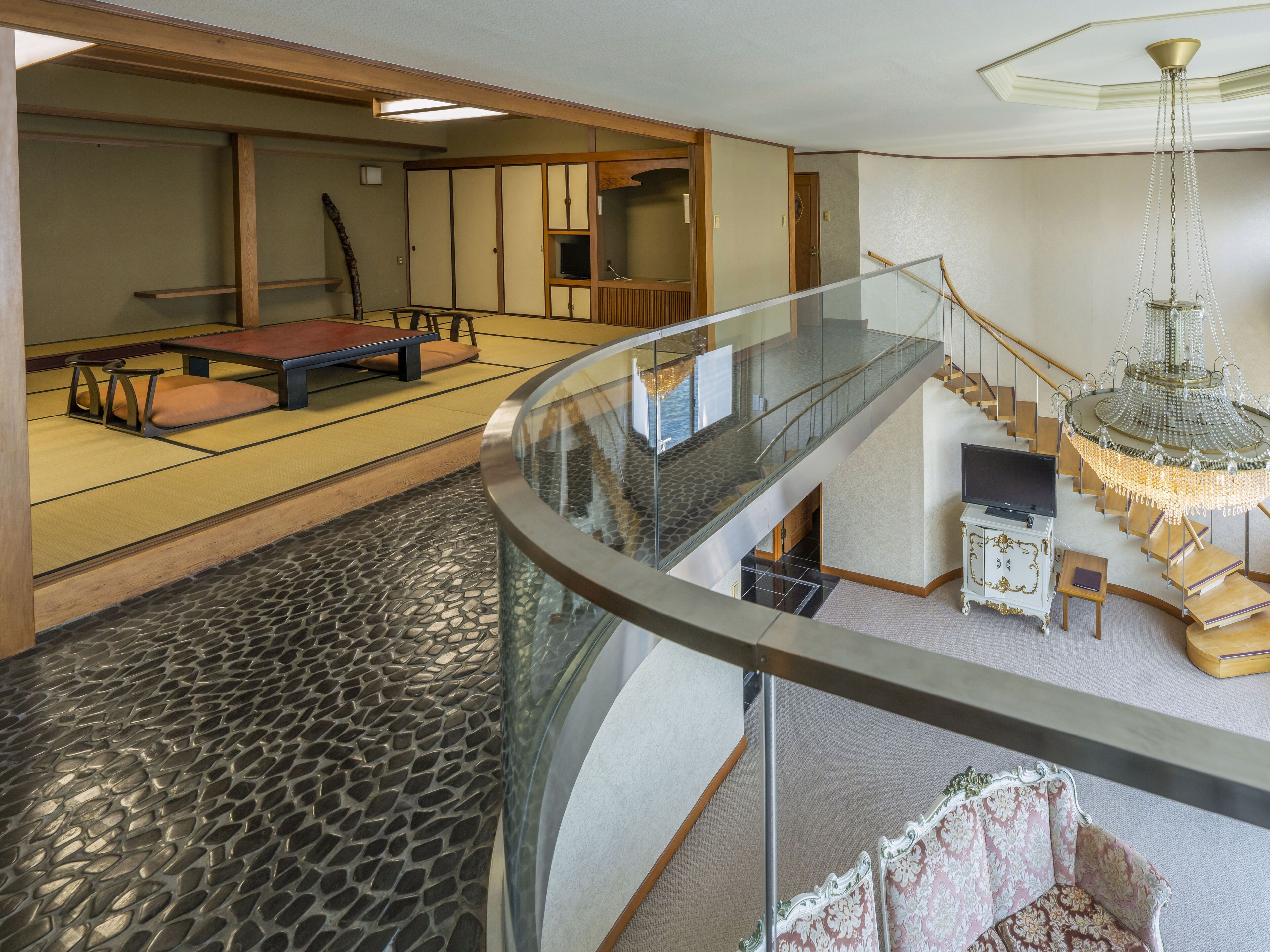 A spacious room with tatami flooring, a low wooden table, and a traditional Japanese room divider.