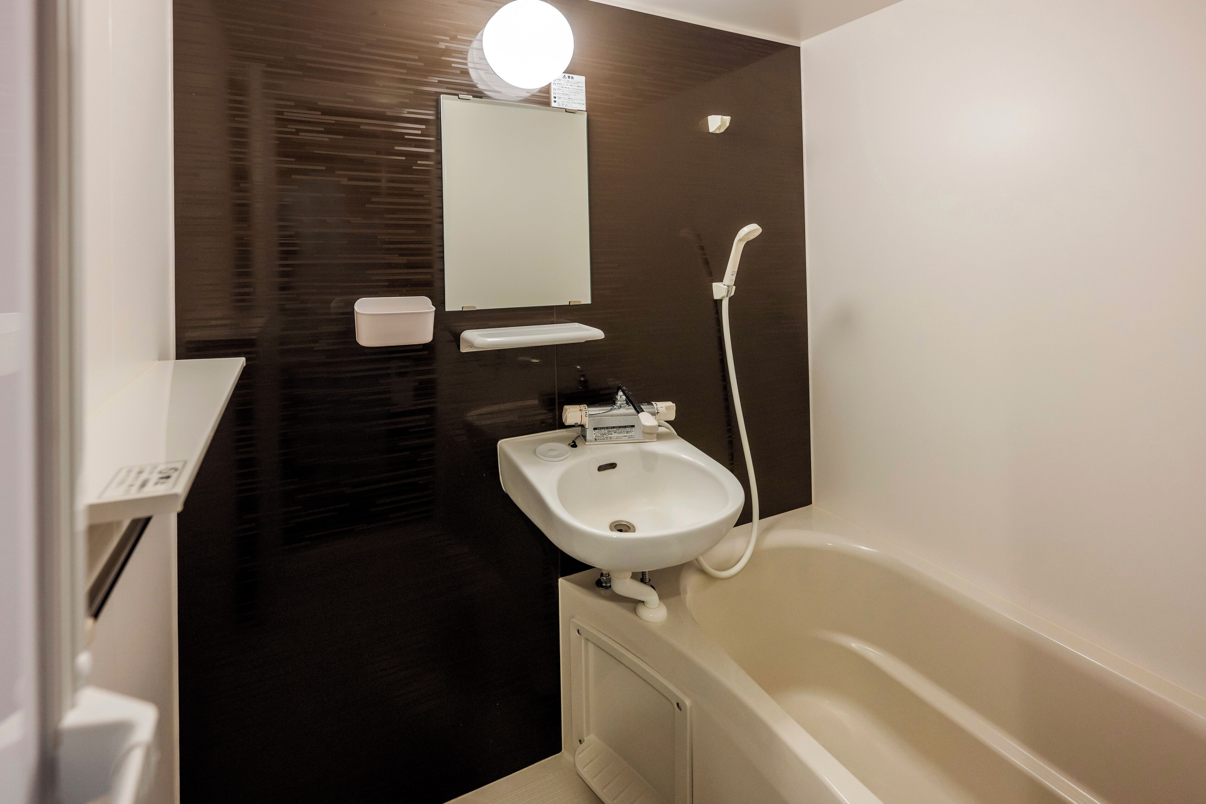Une salle de bain moderne avec un lavabo blanc, un miroir et une baignoire.