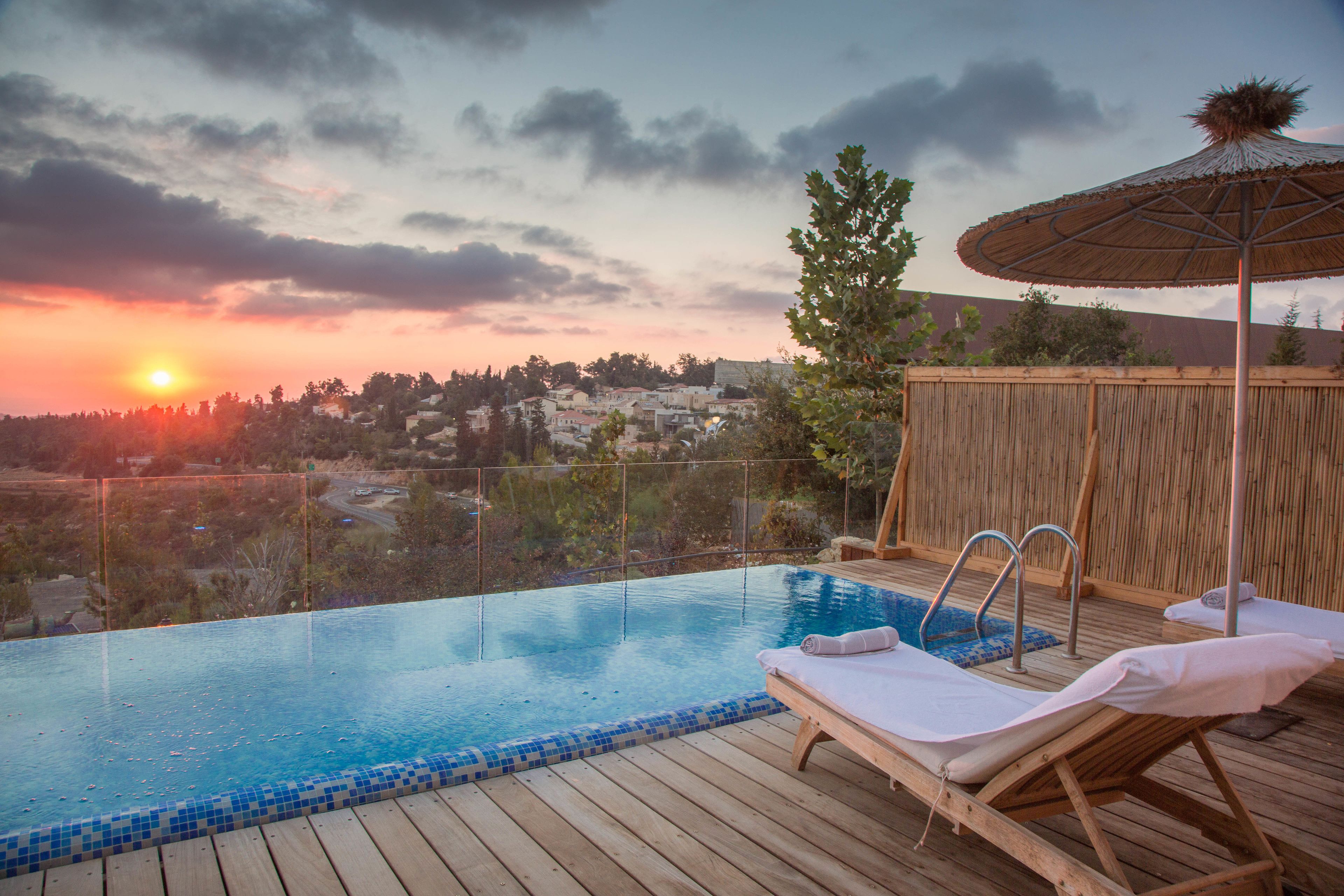 Alberca al aire libre, sombrillas en la alberca y camastros 