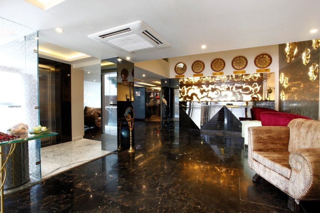 A lobby with a marble floor, a reception desk, a sofa, and decorative wall art.