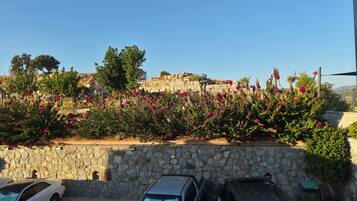 A parking area with stone walls and parked cars.