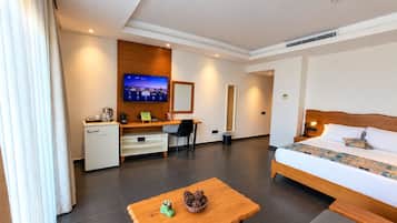 Une chambre d’hôtel avec un lit, un bureau et un téléviseur.