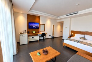 A hotel room with a bed, desk, and a television. - Degirmenburnu Residence (Bodrum)