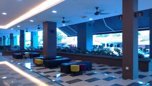 A spacious lobby with high ceilings, multiple seating areas, and large windows offering views of the outside. - Temasek Hotel (Malacca City)