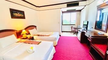 A hotel room with two beds, a desk with a computer, and a TV.