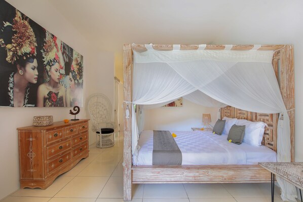 A bed with a canopy, a wooden dresser, and a painting on the wall. - Villa Balissima (Seminyak)