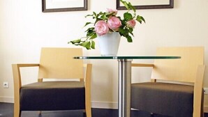 Una habitación con dos sillas y una mesa con un florero.