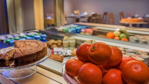 Un bufé con diversas opciones de comida, incluyendo un pastel y naranjas.