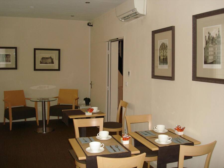 A dining area with tables, chairs, and framed pictures on the walls.