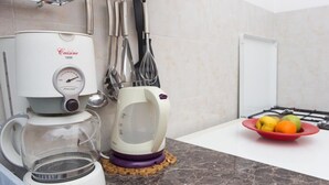 A kitchen with a coffee maker, a kettle, and a bowl of fruit on the counter. - Villa Malfi (Dubrovnik)