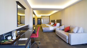 A hotel room with a bed, a sofa, a desk with a coffee maker, and a mirror. - Svalinn Hotel (Izmir)
