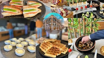 A variety of food items including sandwiches, desserts, and waffles, displayed on a counter in a restaurant setting.