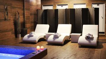 Un área de spa con tres sillas reclinables, una piscina pequeña y una fila de separadores para mayor privacidad.
