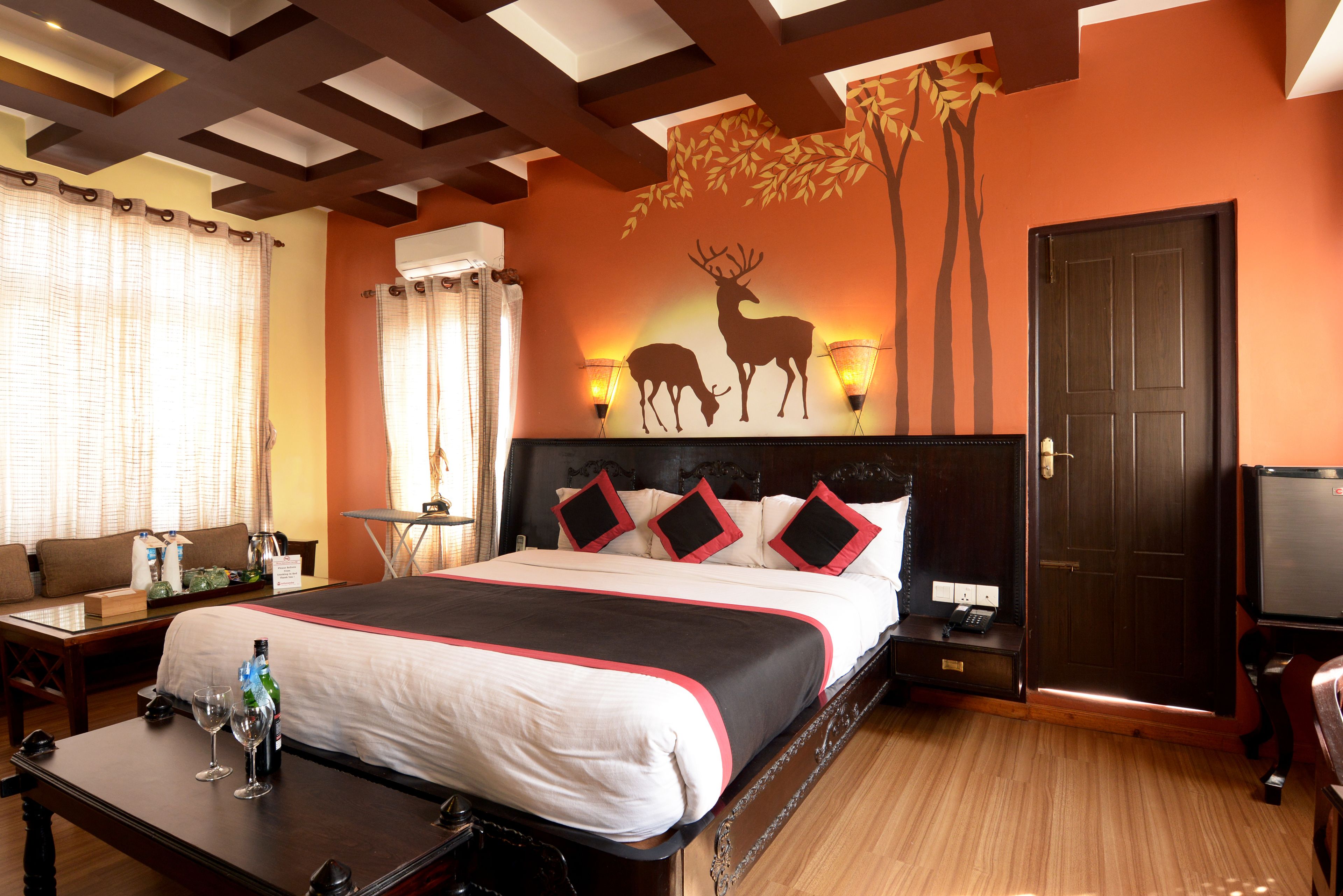 A hotel room with a large bed, a desk with a chair, a TV, and a door.