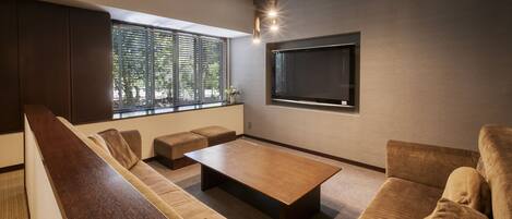 Una sala de estar moderna con un sofá, una mesa de centro y un televisor montado en la pared.