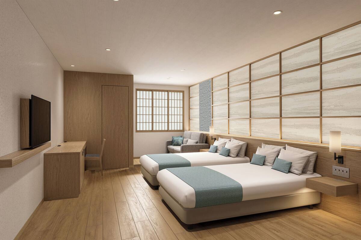 A modern hotel room with a large bed, a TV, a desk, and a window.