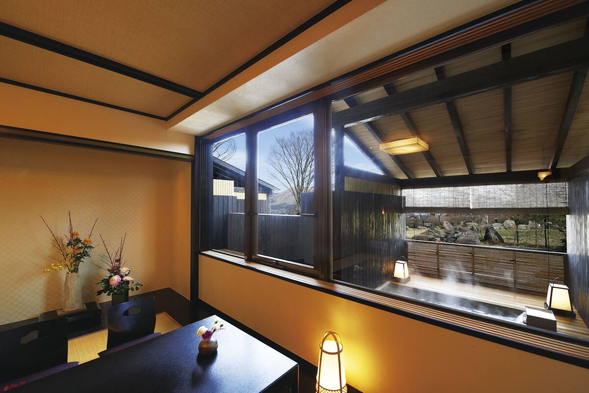 A dining area with a table, chairs, and a window with a view of a garden.