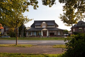 Een hotel met twee verdiepingen en een opvallend ‘HOTEL’ bord boven de ingang.