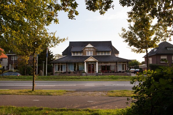A two-story hotel with a prominent 'HOTEL' sign above the entrance.