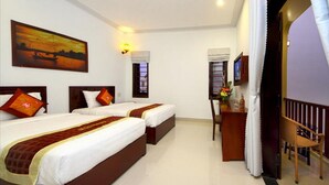 Quarto de hotel com duas camas, uma escrivaninha, uma cadeira, uma televisão e um quadro na parede.