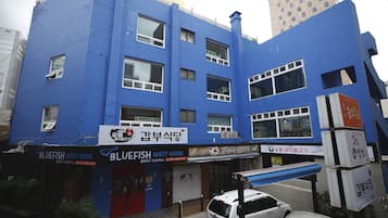A blue building with multiple storefronts, including a Bluefish Guest House.
