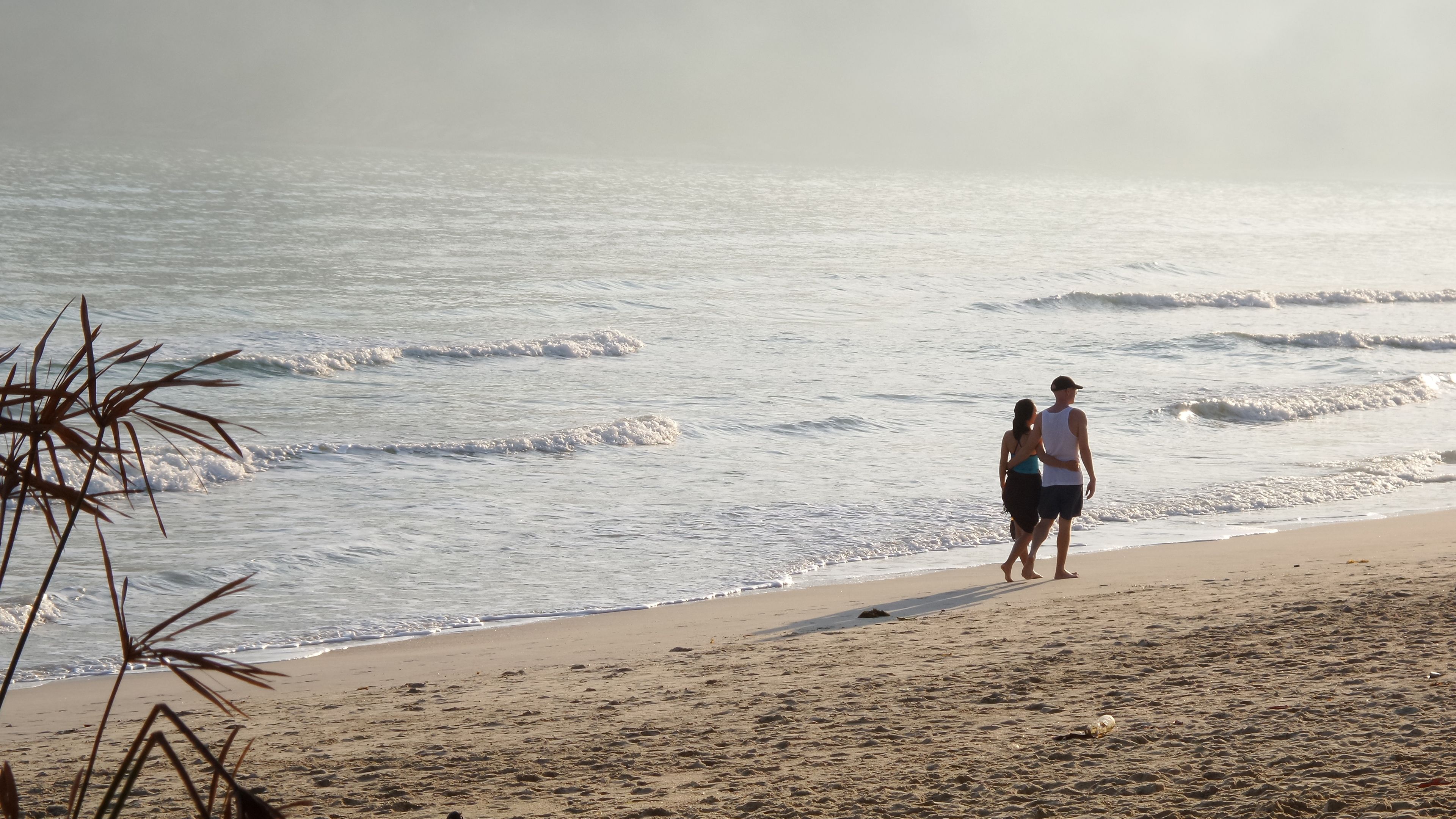 Ein Strand mit sandigem Ufer und Wellen.