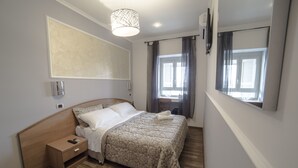 Une chambre à coucher avec un lit en bois, une table de chevet et une grande fenêtre avec des rideaux.