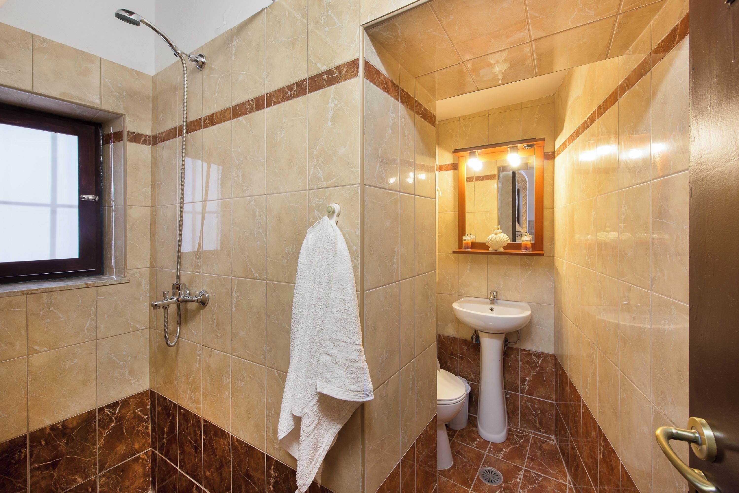 Un baño con ducha, lavamanos e inodoro.