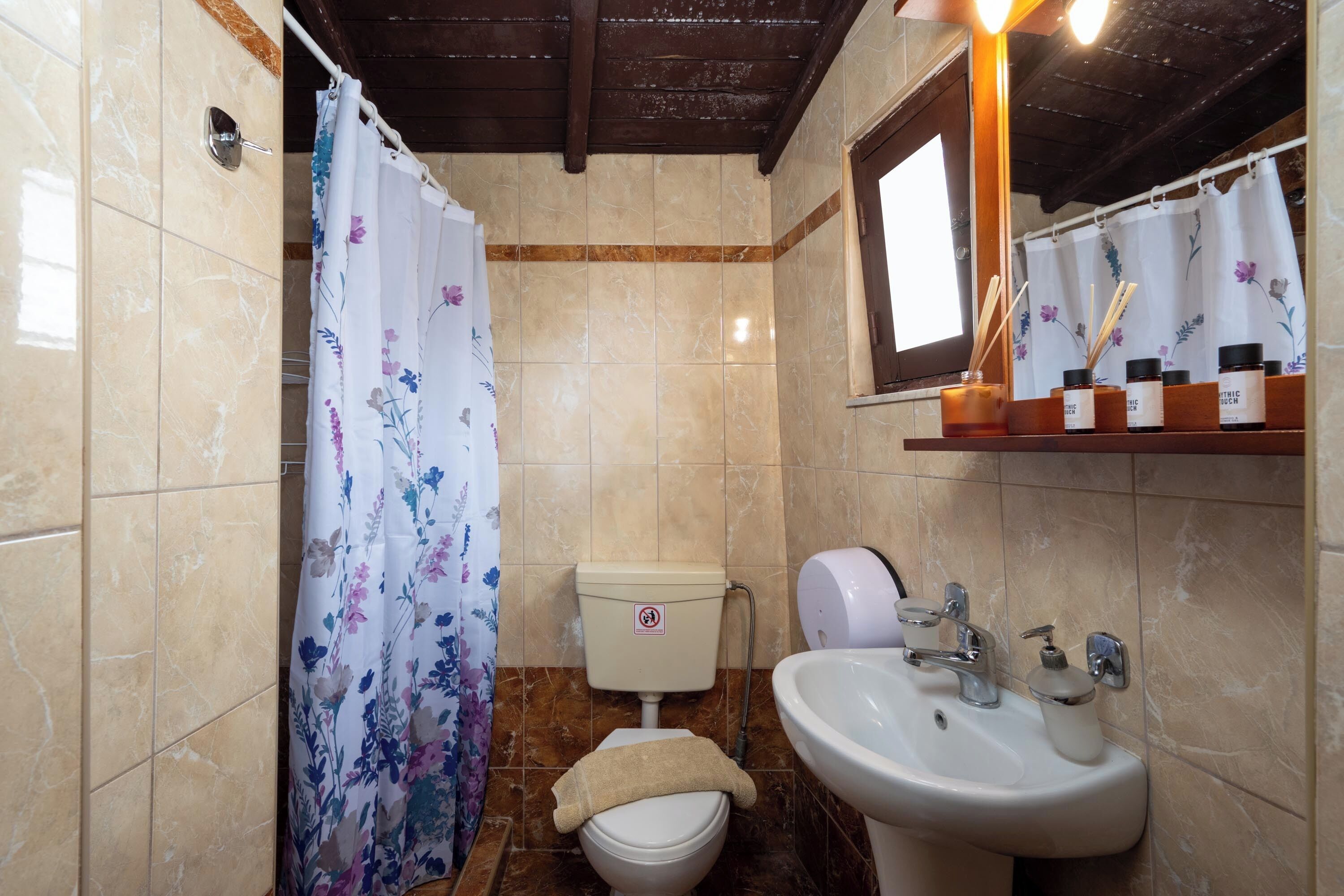 A bathroom with a toilet, sink, and shower curtain.
