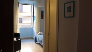 A bedroom with a bed, a window, a door, and a picture on the wall. - Scipione B&B (Rome)