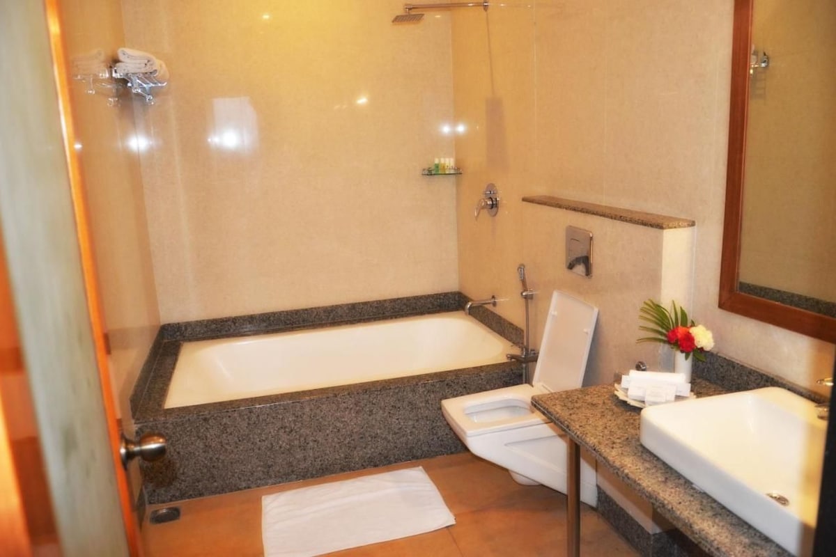 A bathroom with a bathtub, a shower, a toilet, and a sink.