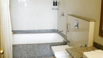 Un baño con bañera, ducha, inodoro y lavabo.
